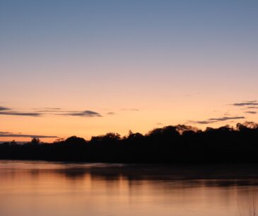 A twilight or evening shot of the Ping River with warm lights, setting a "weekend getaway" mood.